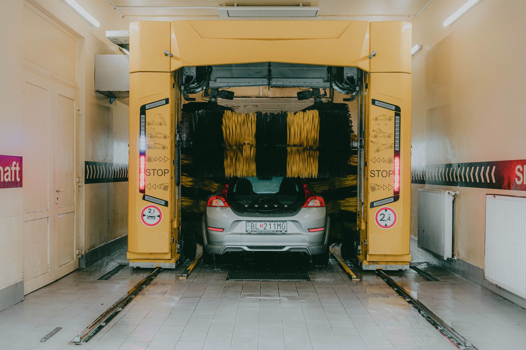 A vehicle surrounded by rotating brushes in an automated car wash